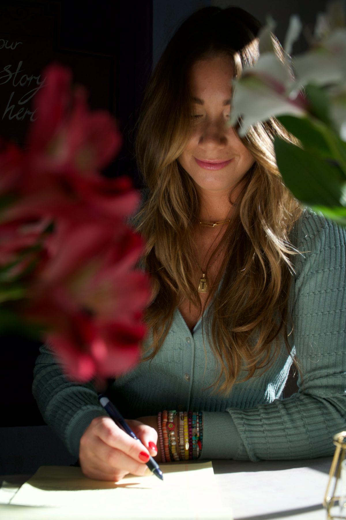 Tabitha writing at a table with flowers