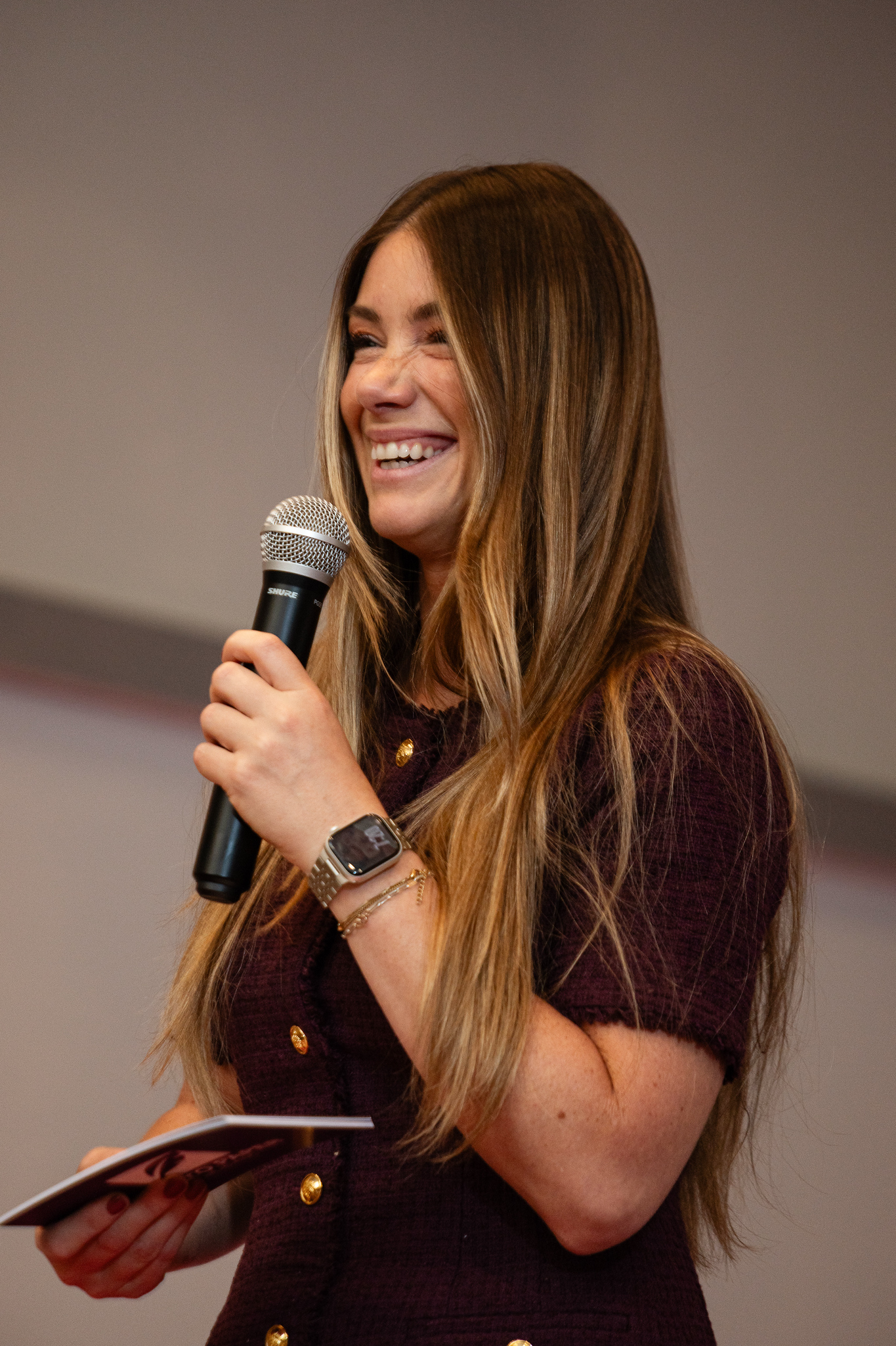 Tabitha Rose laughing on stage with a microphone