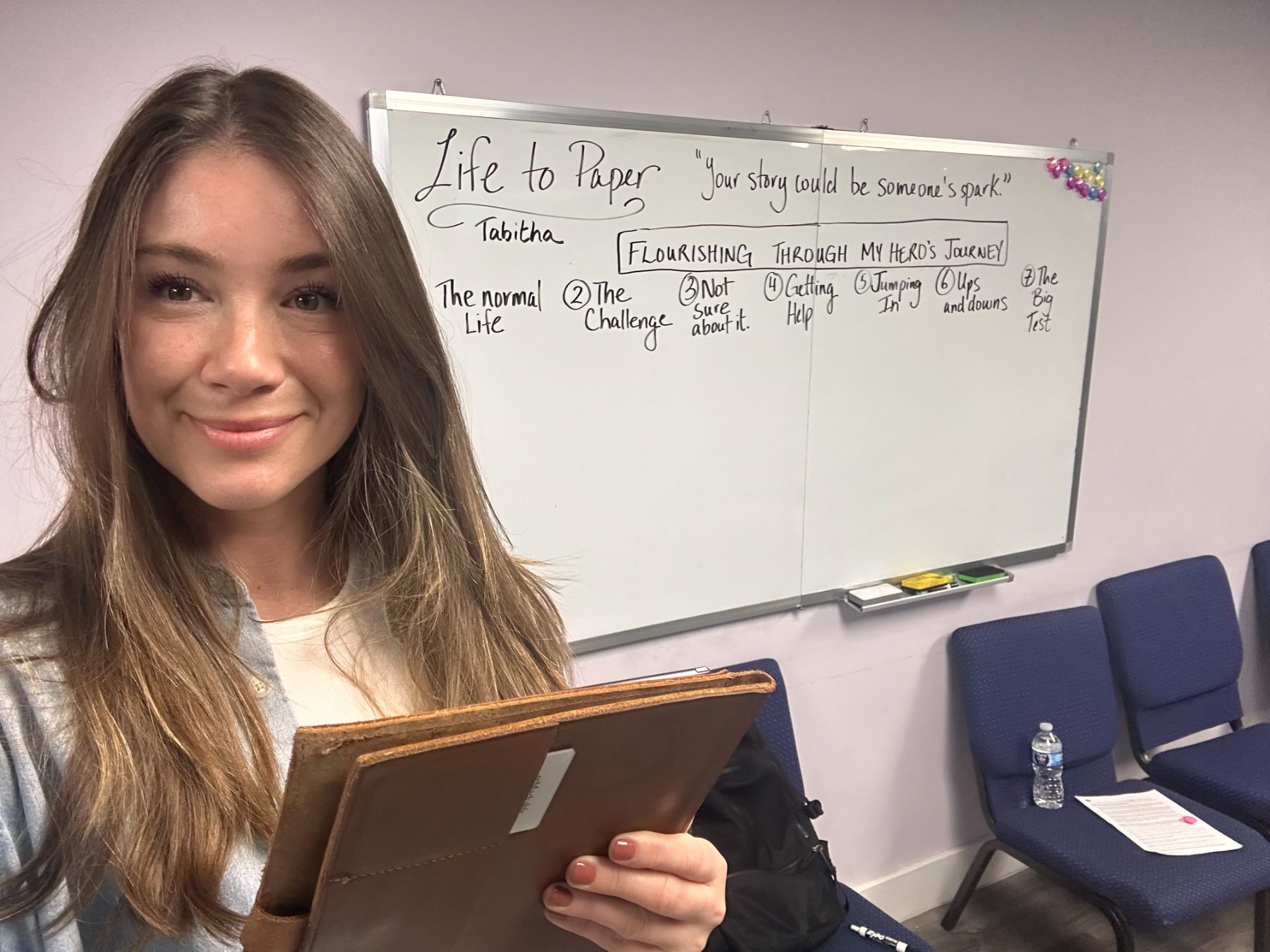 Tabitha Rose teaching in front of a whiteboard at a treatment centre workshop